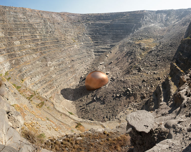 Vue d'artiste d'une mine à ciel ouvert avec tout ce qu'elle a extraite en cuivre, une petite boule au milieu d'un enorme cratère